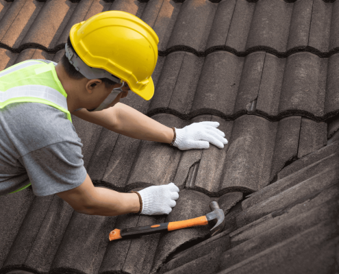 A photo of a homeowner preparing for roof replacement with tools and materials