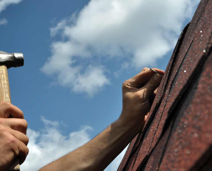 Close-up of a roof technician checking shingle details