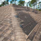 A roof with several missing shingles, indicating potential wind damage
