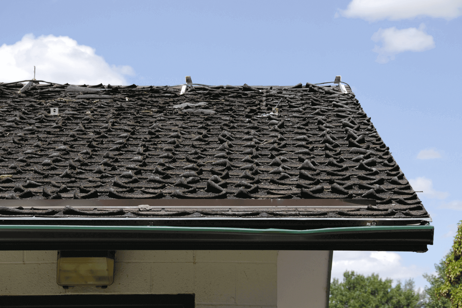 An image showing signs that an asphalt shingle roof needs attention