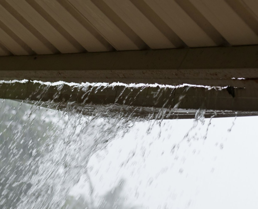 Residential gutter overflowing during a storm