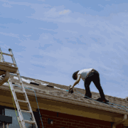 A maintenance check being performed on an architectural shingle roof.