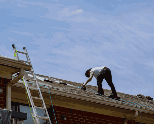 A maintenance check being performed on an architectural shingle roof.