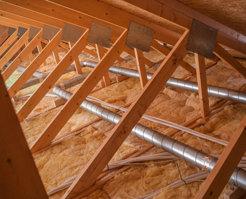 Attic ventilation and insulation Inside an attic: rafters, insulation batts and ventilation ducting under the roof deck