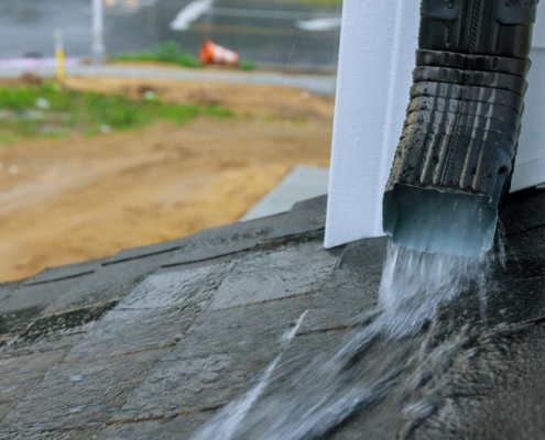 Why Do My Gutters Overflow Every Storm? 5 Rainwater pouring off a house roof edge past the gutter during a storm, Ocean City MD