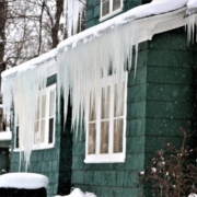 Ice dam with long icicles hanging from the eave of a shore house in winter, Ocean City MD