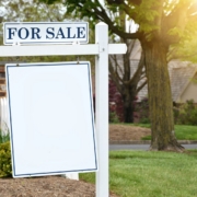 For sale sign in front of a house with its roof visible behind it, Ocean City MD