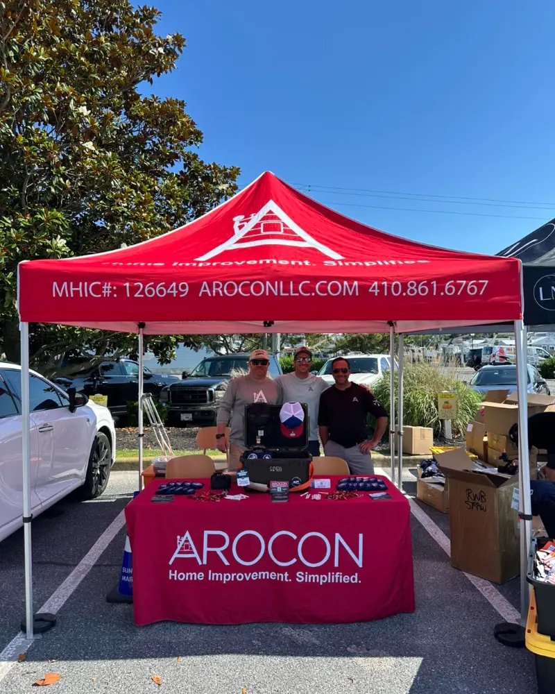 Three AROCON team members at the AROCON tent and table at a local event